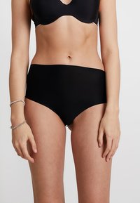Black high-waisted underwear made of smooth fabric. Features a seamless design and a comfortable elastic waistband. No visible stitching.