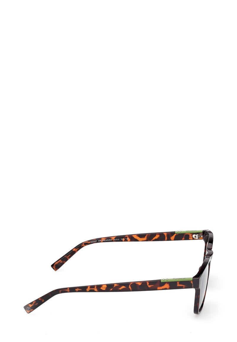 Lunettes de soleil avec un motif écaille de tortue noir et brun, de forme rectangulaire, lentilles foncées et accents verts aux extrémités des branches.
