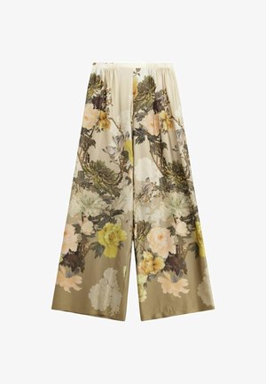 Pantaloni a gamba larga floreali realizzati in tessuto morbido. Presentano grandi motivi floreali gialli, bianchi e verdi su uno sfondo beige. Vita elastica.