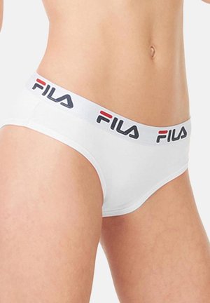 Gros plan d'une personne portant des sous-vêtements blancs de la marque FILA avec une ceinture élastique montrant le logo en noir et rouge.