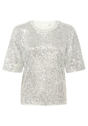Top à manches courtes en sequins argentés avec un col rond. Les sequins couvrent toute la surface, réfléchissant la lumière et créant une apparence texturée.
