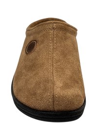 Bruine suède pantoffel met een ronde neus, een gladde textuur, gestikte details en een ronde logo patch nabij de opening. Zwarte rubberen zool.