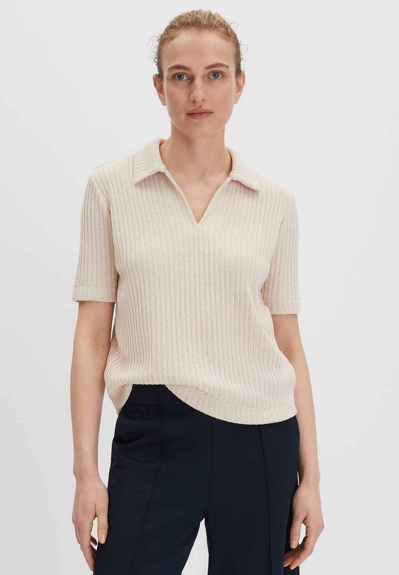 Heller beiger, gerippter Poloshirt-Pullover mit kurzen Ärmeln, V-Ausschnitt und umgeschlagenem Kragen, mit lässiger Passform und subtilen strukturierten Details.