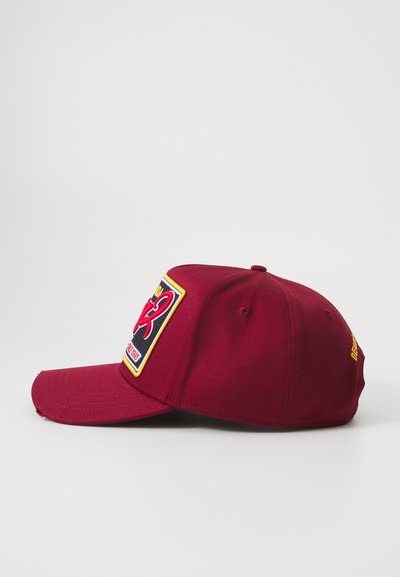 Bordová baseballová čiapka s ohnutým šiltom, na prednej strane s farebnou nášivkou a prešívanými detailmi. Bočné logo v žltej farbe.