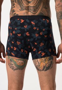 Black boxer briefs with a floral pattern featuring orange and blue flowers. Elastic waistband with the brand name embossed.