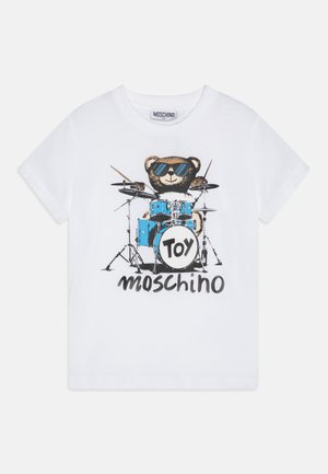 T-shirt de algodão branco com uma ilustração de um urso de óculos de sol a tocar um kit de bateria azul, com o texto "Toy Moschino" abaixo do design.