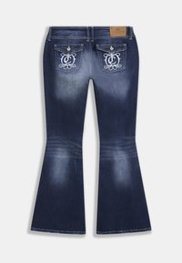 Τζιν καμπάνα από σκουρόχρωμο ντένιμ με ελαφρό ξεθώριασμα, κεντημένες πίσω τσέπες και δερμάτινο ταμπελάκι στη μέση για την επωνυμία.