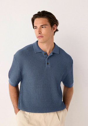 Short-sleeve polo shirt in textured blue fabric with a ribbed design, featuring a collared neckline and three brown buttons.