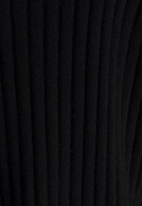 Sort ribt væv med lodrette linjer, blød tekstur og en let dunet finish, som fremhæver stoffets tykkelse og varme.