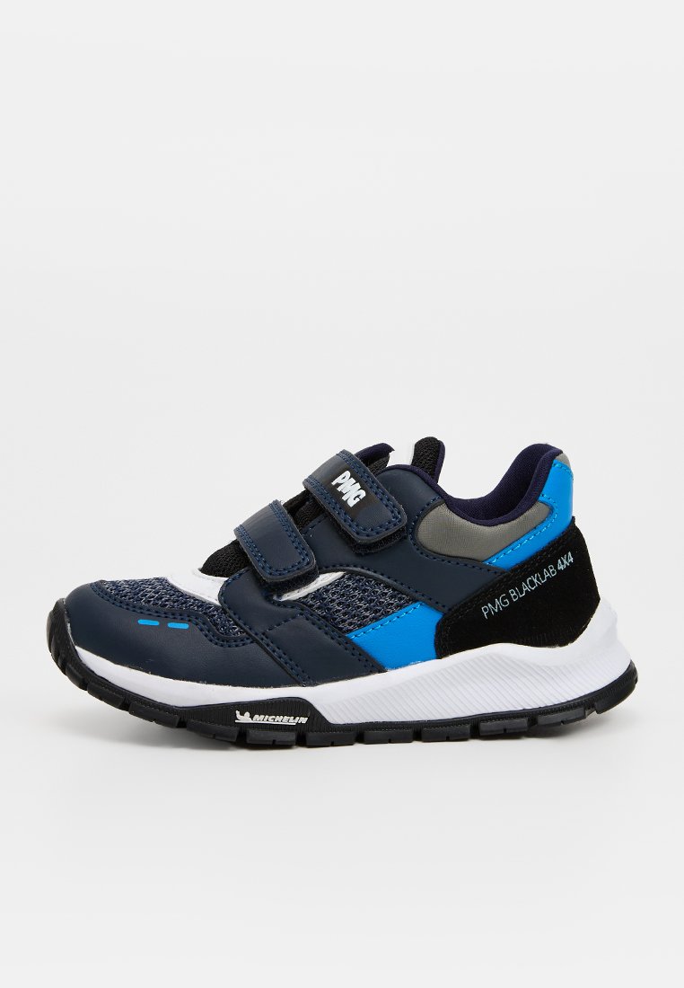 Zapatilla con upper sintético azul marino, paneles de malla y correas de gancho y bucle. Presenta una suela blanca y acentos negros. Logo de Michelin en la suela.