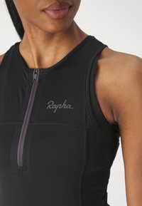 Haut de cyclisme noir en tissu texturé, doté d'une fermeture éclair à l'avant et d'une discrète marque "Rapha". Le design comprend une coupe ajustée et un style sans manches.