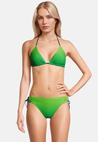 Groene bikini met stippen, voorzien van een driehoekige top en verstelbare zijkanten. Kenmerkt zich door blauwe accenten en een gladde stoftextuur.