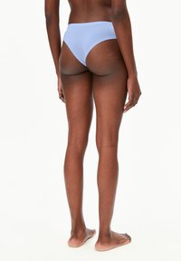 Bas de bikini en coton bleu clair avec une texture lisse, design taille mi-haute et couverture minimale à l'arrière, vu de dos.