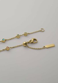 Bracciale in oro con pietre colorate incastonate in montature circolari, chiusura a gancio e un'etichetta incisa con la scritta "iette."