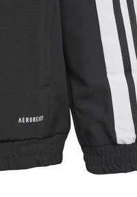 Schwarze Sportjacke mit einem schlanken Design, elastischen Bündchen, weißen Akzentstreifen und einem "AEROREADY"-Logo am Saum.