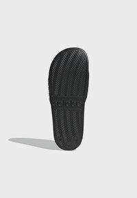 Svart adidas sandal sula med ett fiskbensmönster, texturerat gummimaterial och ingraverad logotyp. Fotbädden är formad för komfort.
