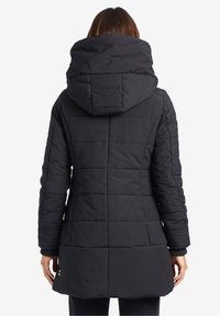 Svart puffjacka med en stor huva, med ett quiltat mönster, långa ärmar och en något utsvängd nederkant. Mjuk, texturerad tyg.