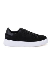 Schwarze Wildledersneaker mit einer glatten schwarzen Lederakzent, runder Spitze, flacher weißer Gummisohle und passenden schwarzen Schnürsenkeln.