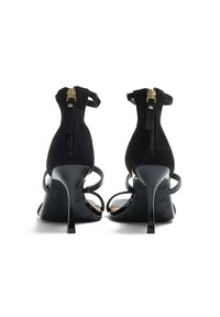 Czarne zamszowe sandały na obcasie z zamkiem z tyłu, cienkimi paskami w kostce i błyszczące, czarne szpilki. Posiadają teksturowaną podeszwę.