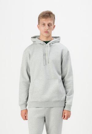 Gray hoodie made of soft fabric with a kangaroo pocket, drawstring hood, and ribbed cuffs. Worn with matching gray sweatpants.