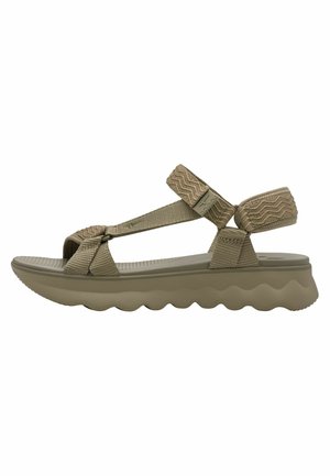 Beige sandal med teksturerede stofremme, justerbare ankel- og tåsløjfer samt en polstret bølget sål for støtte og komfort.