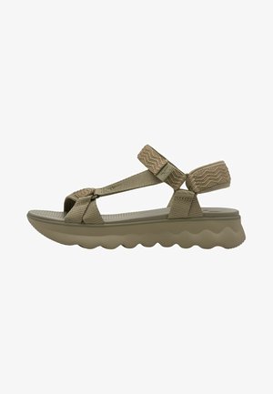 Beżowa sandałka z teksturowanymi paskami z tkaniny, regulowanymi pętlami na kostkę i palce oraz wyściełaną falistą podeszwą zapewniającą wsparcie i wygodę.