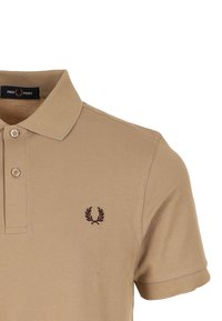 Beige polo-shirt van ademend katoen, met een drieknoopsluiting, geribde kraag en een klein donkerbruin logo op de borst.