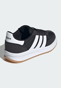 Čierna športová obuv s bielymi tromi pruhmi a brandingom, vrchný materiál s textúrou, polstrovaný golier, biela medzipodrážka a podošva z gumy.
