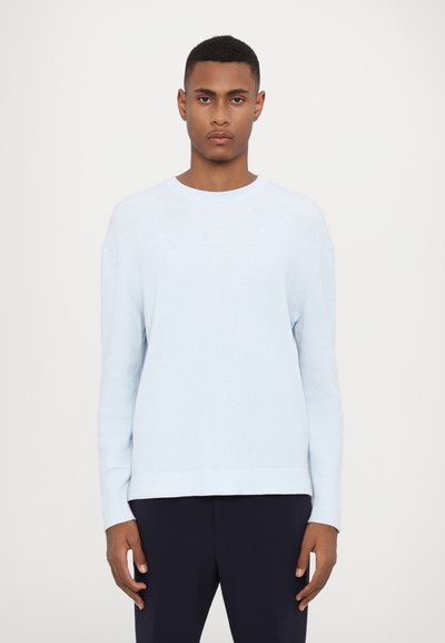 Himmelblauer Strickpullover mit langen Ärmeln, rundem Ausschnitt und lockerer Passform. Der Stoff hat eine weiche Textur und minimalistische Muster.