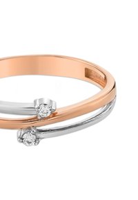 Bague bicolore avec des bandes en or rose et en argent qui se croisent, chaque bande ornée d'un petit diamant rond à l'intersection.