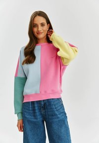 Bluza w różowe, niebieskie i żółte panelem, z luźnym krojem i długimi rękawami w desenie z bloków kolorowych. Miękka tekstura materiału.