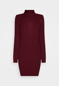 Robe en tricot côtelé bordeaux avec un col montant, des manches longues et une silhouette ajustée, présentant un détail en forme de V à l'avant.