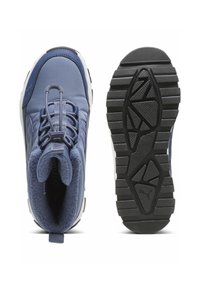 Zapatillas deportivas azules con un collar acolchado, tejido texturizado y suelas de goma con un patrón de banda geométrico. Diseño con cordones y detalle de marca.