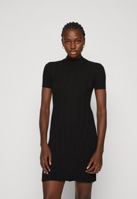 Black ribbed knit dress with short sleeves and a high neckline, featuring a fitted silhouette and a slightly flared hemline.