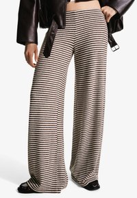 Striped wide-leg pants made of a soft material, featuring a beige and brown color scheme, with a relaxed silhouette and high waist design.