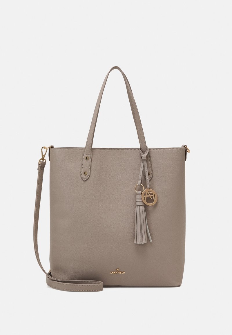 Šedá kožená tote taška s dvěma uchy, odnímatelným popruhem, akcentem v podobě třásně a zlatými kovovými prvky. Obsahuje logo a strukturovaný povrch.