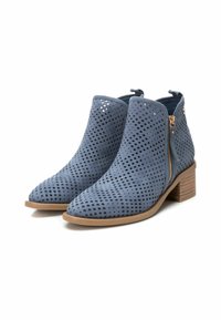 Stivali alla caviglia in suede blu con design perforato, punta affusolata e chiusura con zip, dotati di tacco a blocco in legno.