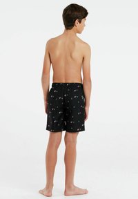 Zwarte zwemshorts met kleurrijke vissen en ankerpatronen, elastische tailleband en zijzakken, getoond op een jongen van achteren.