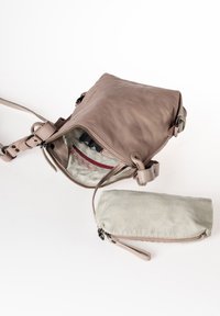Borsa a tracolla in pelle marrone chiaro con chiusura a zip, tracolla regolabile e una borsa in tessuto a righe. L'interno presenta una fodera chiara con tasche.