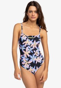 Roxy badpak in marineblauw met een kleurrijk bloemenpatroon, dunne bandjes en een logo op de borst. Glad, stretchy materiaal.
