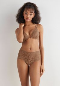 Hnědý květinový krajkový bralette a vysoké kalhotky, s vlnitými okraji a složitými vzory, jemnou texturou a nastavitelnými ramínky.