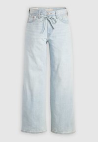 Jean bleu clair à jambes larges avec poches avant, passants de ceinture, fermeture par bouton et ceinture en tissu nouée à la taille.