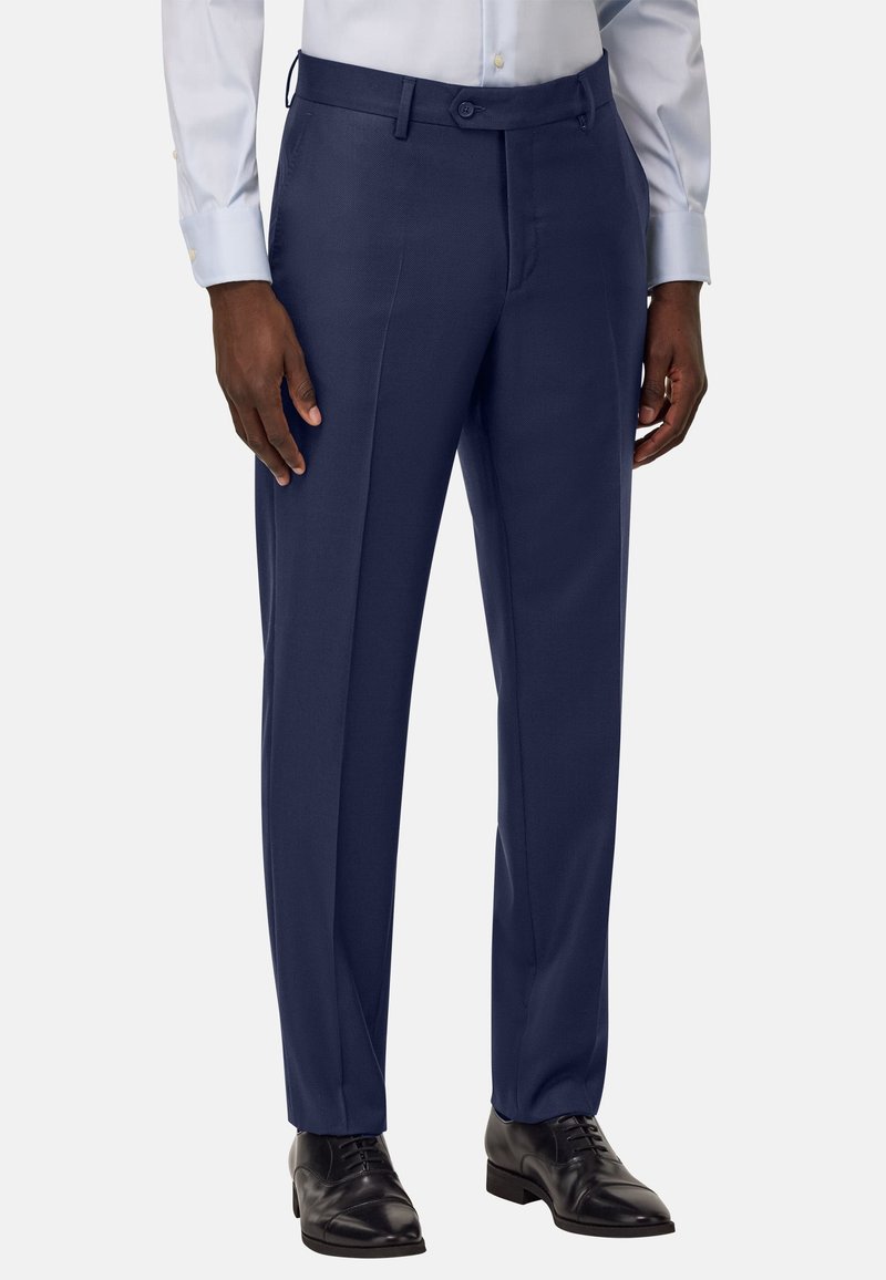 Pantalon tailleur navy au tissu lisse, à l'avant plat, avec deux poches latérales. Fait en tissu léger, avec une fermeture à bouton.