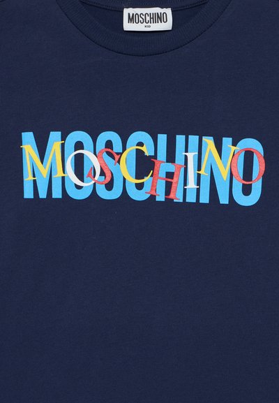 T-shirt in cotone blu navy con la scritta "MOSCHINO" in lettere multicolori, in grassetto e con font e dimensioni diverse, posizionata in modo prominente sul petto.