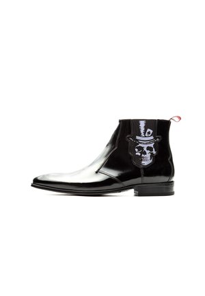 Black leather ankle boot with pointed toe, low heel, and skull wearing top hat graphic on side panel.