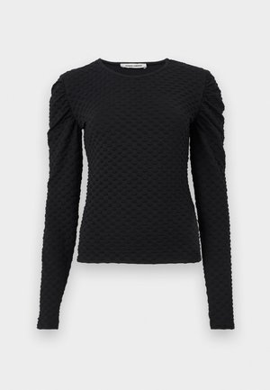 Black long-sleeve textured top with raised dot pattern and subtle puffed shoulders, crew neckline, and fitted silhouette.