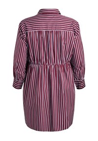 Kobieta w sukience koszulowej w bordo w paski, z wcięciem w talii, rękawami o długości 3/4 i zapięciem na guziki przy mankietach. Posiada pionowe białe paski oraz kołnierzyk.
