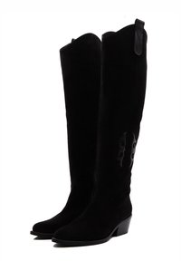 Botas de ante negras hasta la rodilla con punta afilada, tacón bajo apilado y diseño decorativo en el lateral. Cuenta con una lengüeta para facilitar su uso.