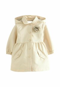 Manteau beige clair avec une capuche, un col arrondi et une fermeture à boutons. Comprend des poches latérales et une fleur en tissu décorative sur la poitrine.