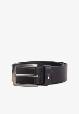 Zwarte leren riem opgerold met een zilveren metalen gesp en een klein rechthoekig logo met rode, witte en blauwe kleuren op de lus.